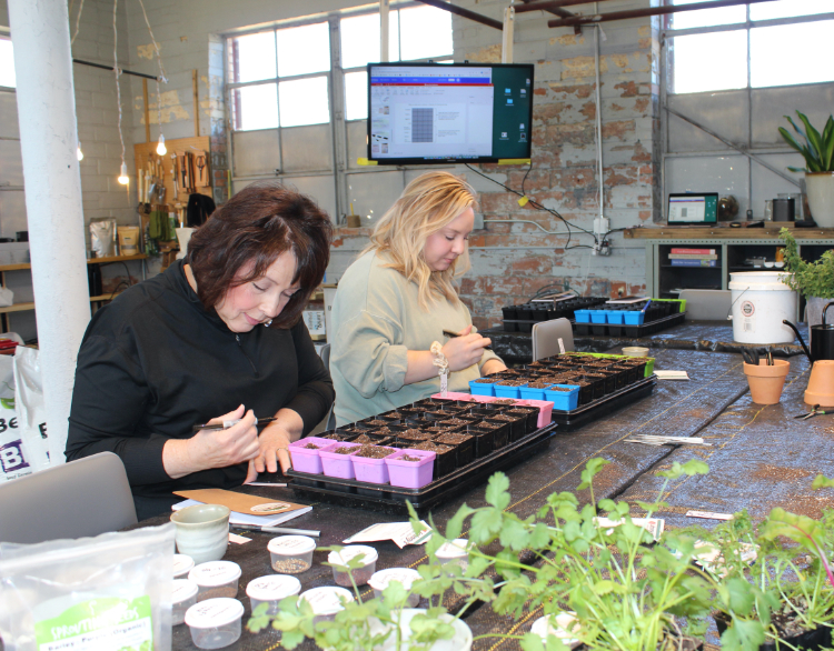 Two students seeding starter trays at a hands-on Grower's Life plant class